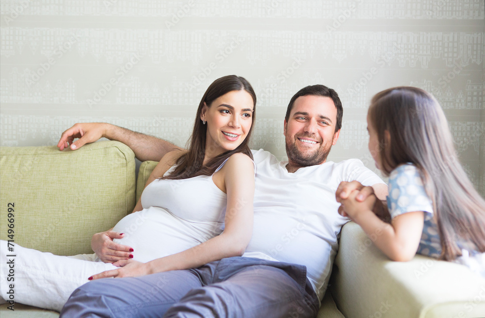 Adorable young pregnant family in living room Adorable young pregnant family in living room