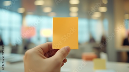 man holding empty blank yellow paper note with urban modern indoor office building as background, idea for memory improvement and memorize concept, Generative Ai