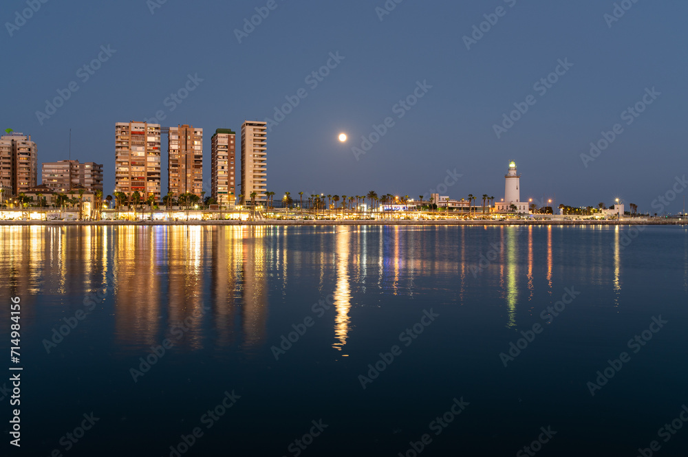 Malaga, Spanish town, coastal area with lighthouse at night