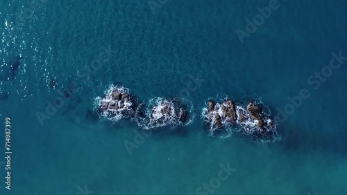 Onde del mare che si infrangono sugli scogli in mezzo al mare. Vista aerea dall'alto verso il basso dell'oceano - Panorama Azmut - Video 4k photo