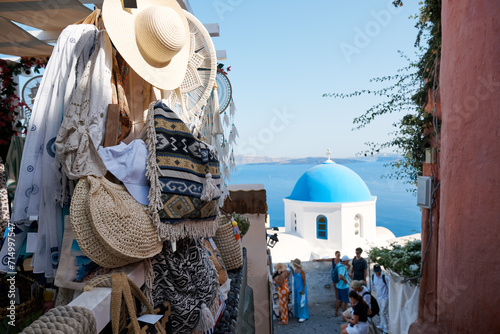 Fototapeta Naklejka Na Ścianę i Meble -  Street with shops and souvenirs for tourists in Oia, Santorini Island. Santorini is a volcanic island in the Aegean Sea and a famous summer resort.