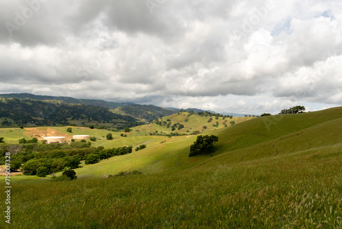 Panoramic view of the Lagoon Valley Park in Vacaville, California, USA, featuring the chaparral with green grass and spotty light and cloudy sky copy space
