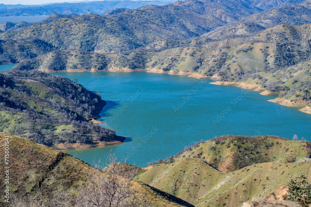 Aerial view of Lake Berryessa from the Blue Ridge Trail, Stebbins Cold Canyon, on a sunny day, featuring the surrounding blue oak woodland and the cove marina