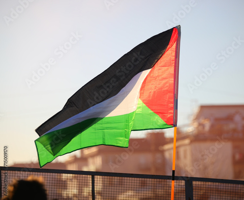 Palestinian flag flying in the suburban suburbs backlit at sunset photo