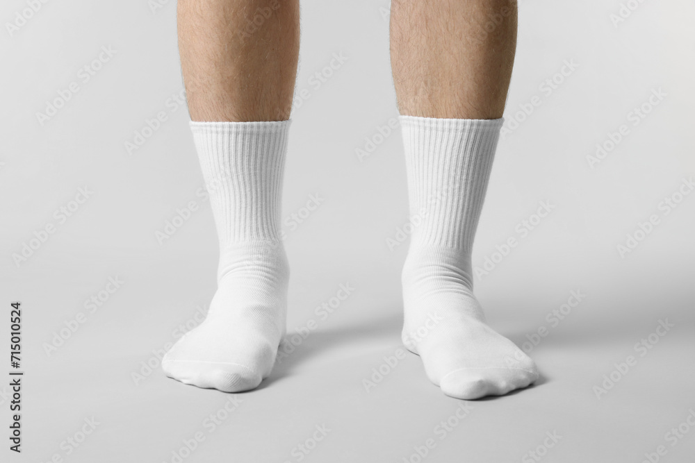Man in stylish white socks on light grey background, closeup Man in stylish white socks on light grey background, closeup