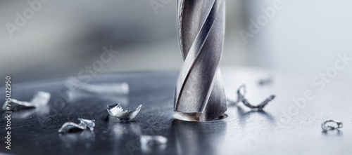 metal drill bit make holes in steel billet on industrial drilling machine photo