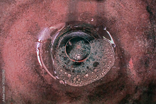 abstract reddish background of liquid pouring through a hole. Plumbing repair