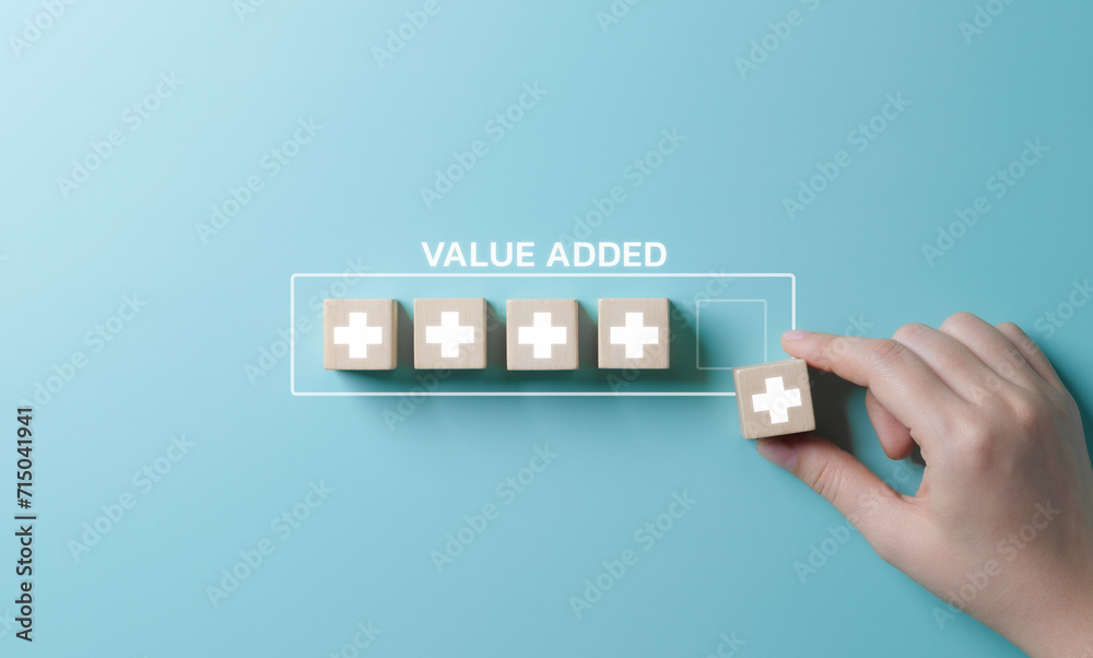 Value add concept. Hand place wooden cube with plus sign on light blue background. Positive thinking or personal growth and development. download style which means value added. value add for business. - obrazy, fototapety, plakaty 