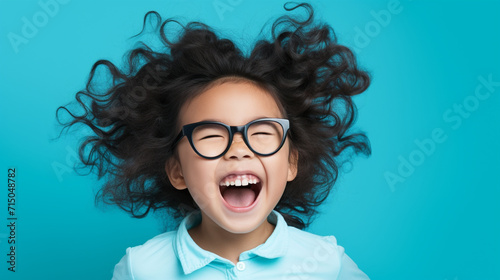 Happy little asian girl isolated on blue background