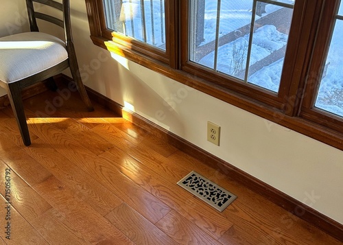 Late afternoon shaft of light streaming onto oak hardwood floors in a suburban home