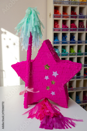 pink star made of cardboard, piñata star for birthday on the table
