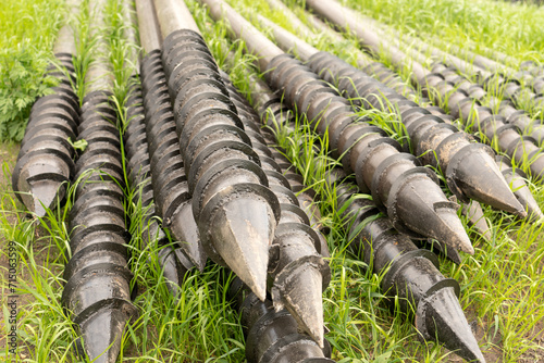 Screw piles for terrace foundations. Geo screws are steel round elements of an engineering structure. Industrial maintenance of metal tools for architectural construction work.