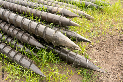 Screw piles for terrace foundations. Geo screws are steel round elements of an engineering structure. Industrial maintenance of metal tools for architectural construction work.