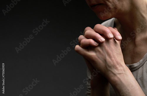 woman praying with hand over her face on black background with people stock image stock photo