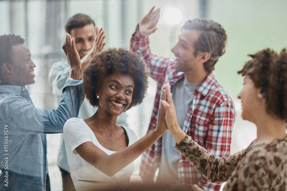 Obraz premium Successful business people giving each other a high five in a meeting