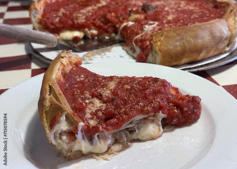 A slice of thick Chicago style pizza with sausage and pepperoni