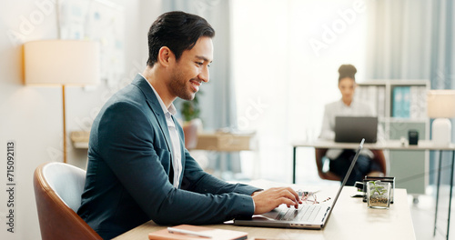 Laptop, typing and happy asian business man in office smile for email, planning or feedback report in coworking space. Online, review and Japanese male manager with proposal, research or satisfaction photo