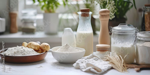 Raw Potatoes and Milk for Cooking. Ingredients for homemade potato milk on table background with copy space. photo