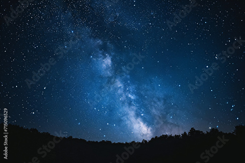 Starry night sky over a forest silhouette. Milky Way galaxy visible. Astronomy and exploration concept for design and print 