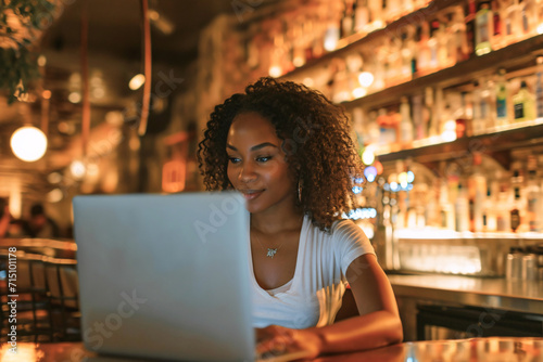 young beautiful dark-skinned girl working on a laptop in a cafe