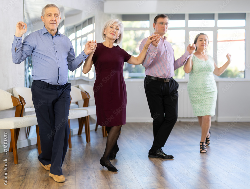 Fototapeta premium In dance studio students group of different ages performs Irish folk dance round dance. Modern hobby for active people.