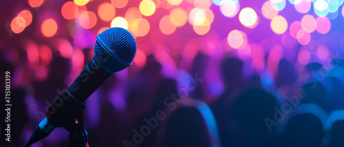 Microphone awaits the next performer against a backdrop of a vibrant concert crowd