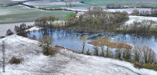 Lowland fens meadow winter snow ice, drone aerial wetland swamp Hrdiboricke ponds icy frozen, endangered habitat natural monument, reed common broadleaf cattail bulrush pond cold Europe photo