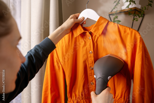 Quadro su tela woman ironing dress with clothes steamer at home