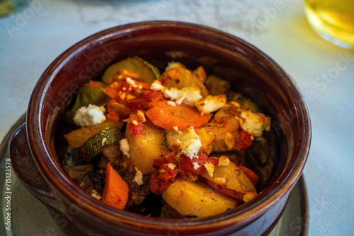 Fresh cooked vegetables such as zucchini and potatoes with feta cheese on top, Greek cuisine, Modern style traditional Greek briam with sliced vegetable
