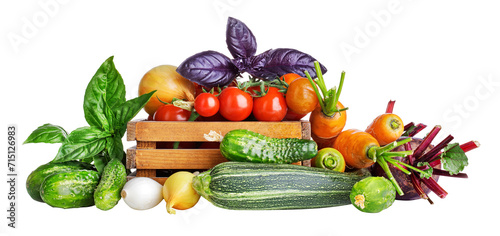 Fresh vegetables in rustic wooden box. Basil leaves, cucumbers, zuccini, carrots and tomatoes from the kitchen garden. Organic natural food. Isolated. PNG. © Yasonya