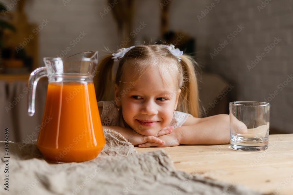 Cute little blonde girl drinking fresh orange juice in the kitchen Cute little blonde girl drinking fresh orange juice in the kitchen
