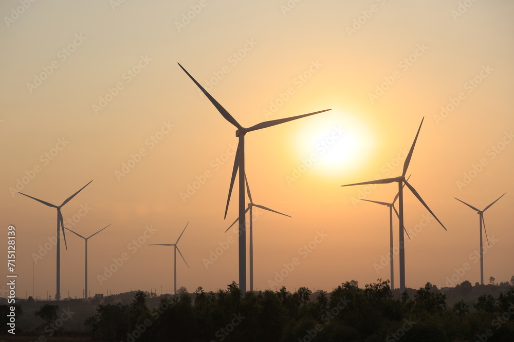 Silhouette windmill or Wind Turbine farm against rising sky, Eco green energy, renewable energy Silhouette windmill or Wind Turbine farm against rising sky, Eco green energy, renewable energy