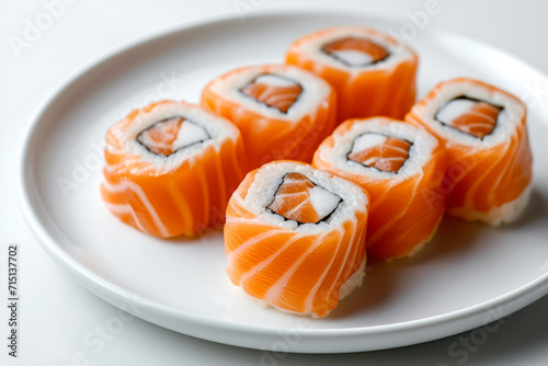 six salmon sushi on white plate on white background