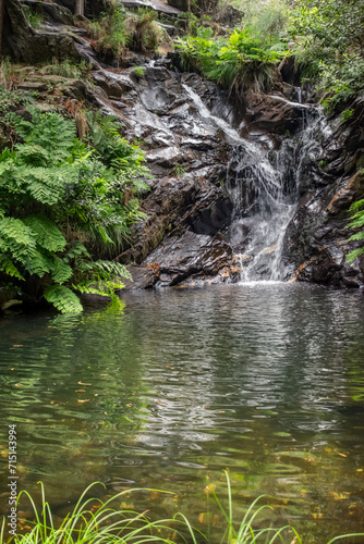 Blurred water flowing through black stones in the waterfall of Paredes with ferns and clear water, Mortágua PORTUGAL
