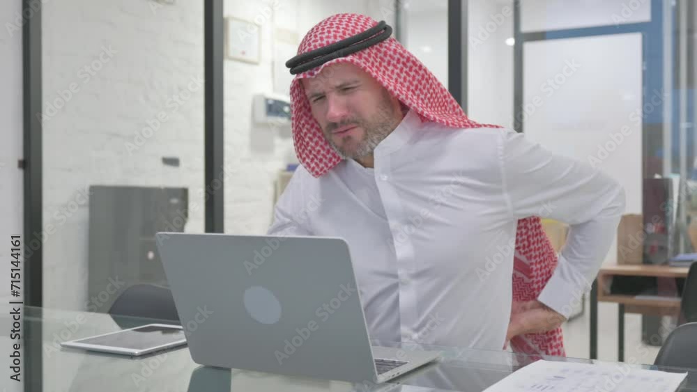 Middle Aged Muslim Man having Spinal Spasm at Work Middle Aged Muslim Man having Spinal Spasm at Work