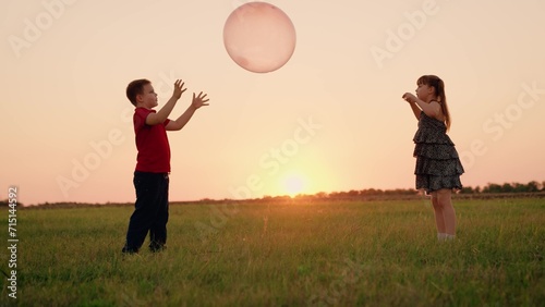 Girl Child Boy Kid playing big ball sunset, children dream flying, happy family, we are joyful, team, small group friends standing field, small team journey happiness, game filled with pure excitement