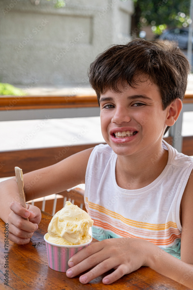 10 year old Brazilian child eating ice cream on a sunny afternoon_1. 10 year old Brazilian child eating ice cream on a sunny afternoon_1.