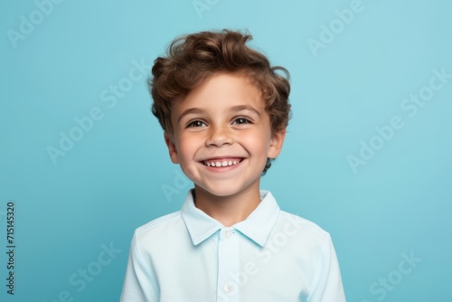 Portrait of a smiling little boy in a shirt on a blue background