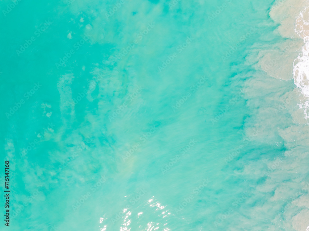 Top view beach with waves crashing on sandy shore,Beautiful waves sea surface in summer seascape background,Amazing beach colorful water background Top view beach with waves crashing on sandy shore,Beautiful waves sea surface in summer seascape background,Amazing beach colorful water background