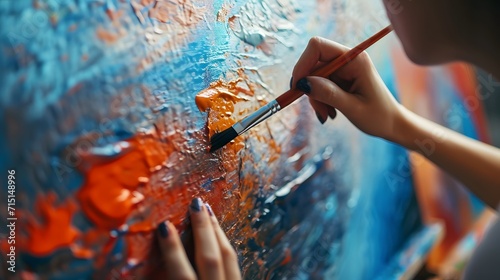 woman artist applying paint on an easel with big brush. artist painting a picture