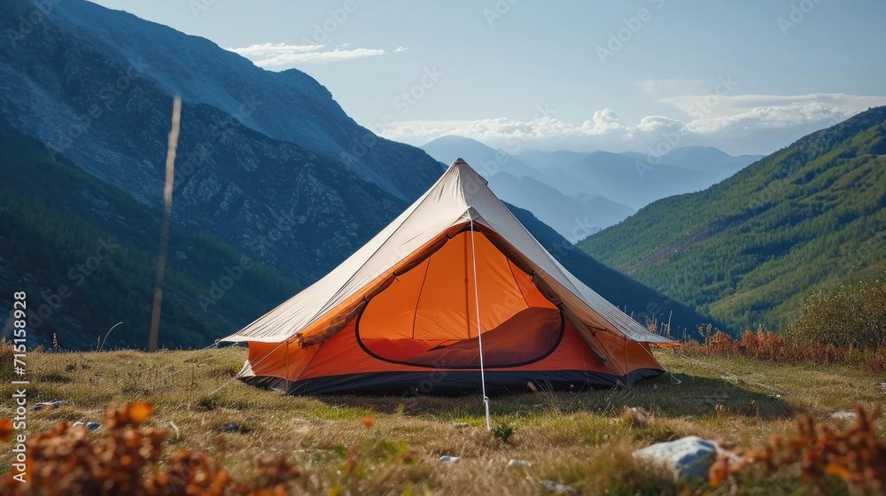 A tent pitched up in a field with mountains in the background