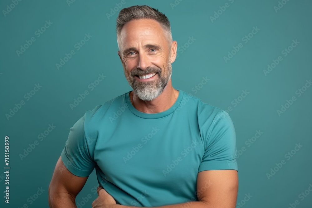 Portrait of a handsome mature man in blue t-shirt, isolated on blue background Portrait of a handsome mature man in blue t-shirt, isolated on blue background