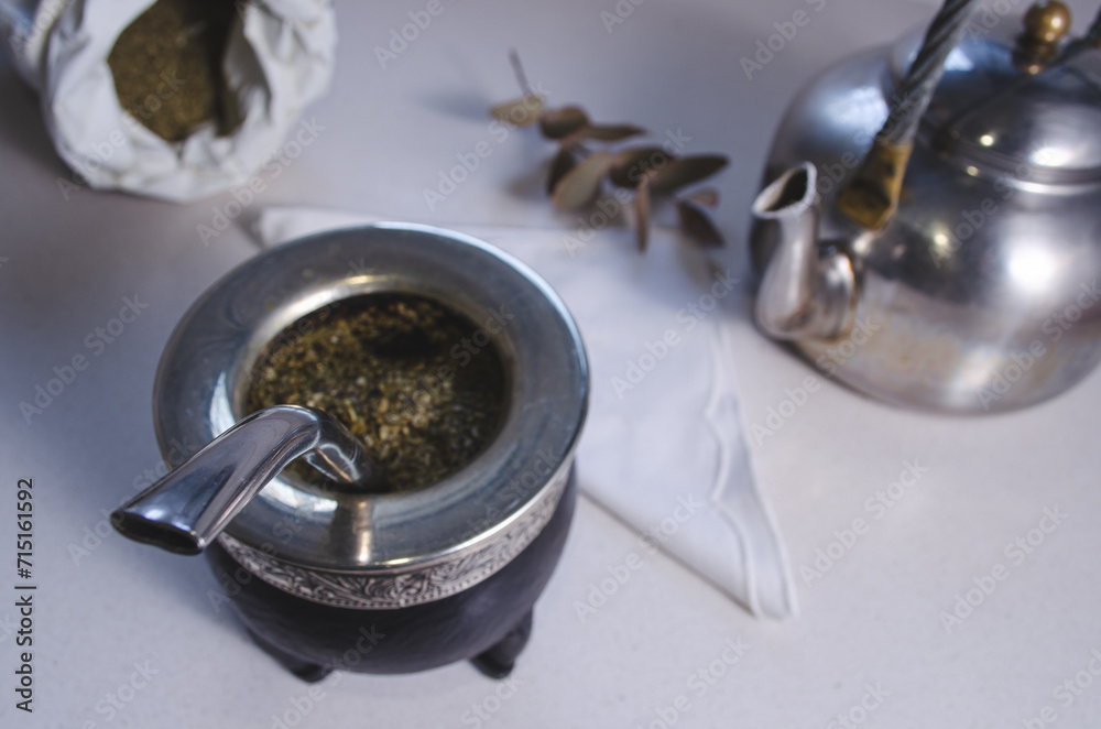 Traditional Argentine mate with yerba mate on a light countertop. Traditional Argentine mate with yerba mate on a light countertop.