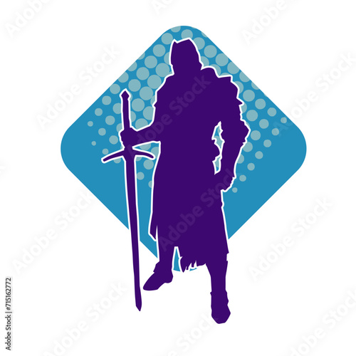 Silhouette of a male warrior wearing war armor suit in action pose using a sword weapon.