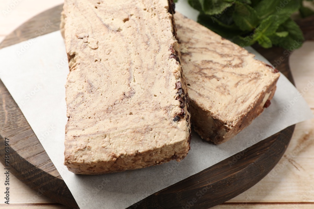 Pieces of tasty chocolate halva on wooden table, closeup Pieces of tasty chocolate halva on wooden table, closeup