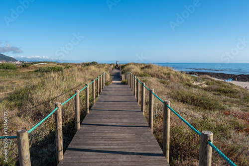 Wooden walkway on the dune of Carreço beach with silhouette in the background, Viana do Castelo PORTUGAL
