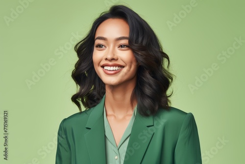 smiling young asian businesswoman in green suit over green background