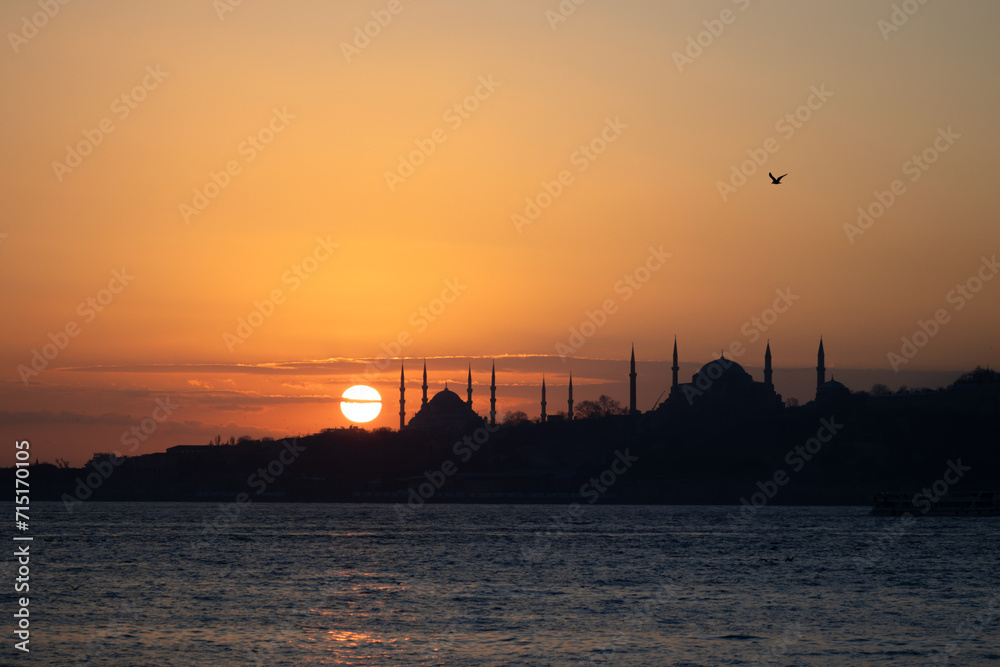 View of Istanbul's historical peninsula at sunset. View of the Sultanahmet Mosque located on the historical peninsula in silhouette.