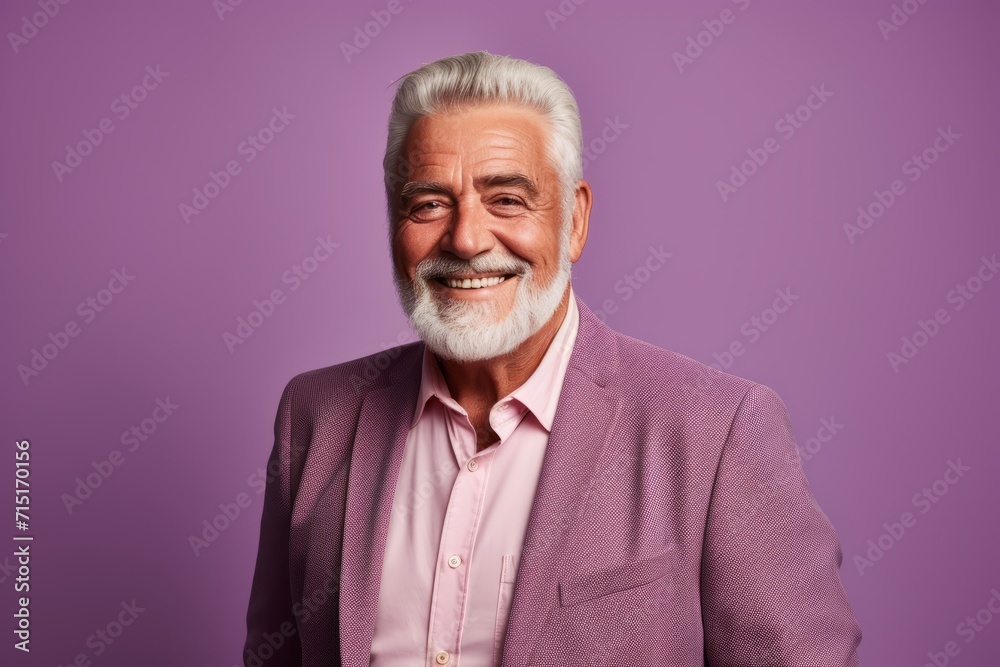 Portrait of smiling senior man in pink suit. Isolated on purple background. Portrait of smiling senior man in pink suit. Isolated on purple background.