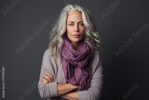 Portrait of a beautiful middle-aged woman with gray hair wearing a scarf.